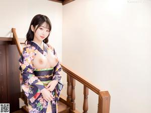 A woman in a kimono sitting on a window sill.