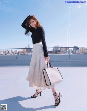 A woman in a long skirt is posing for a magazine.