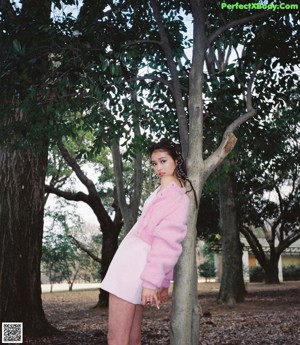 A woman in a pink coat is posing for a magazine.