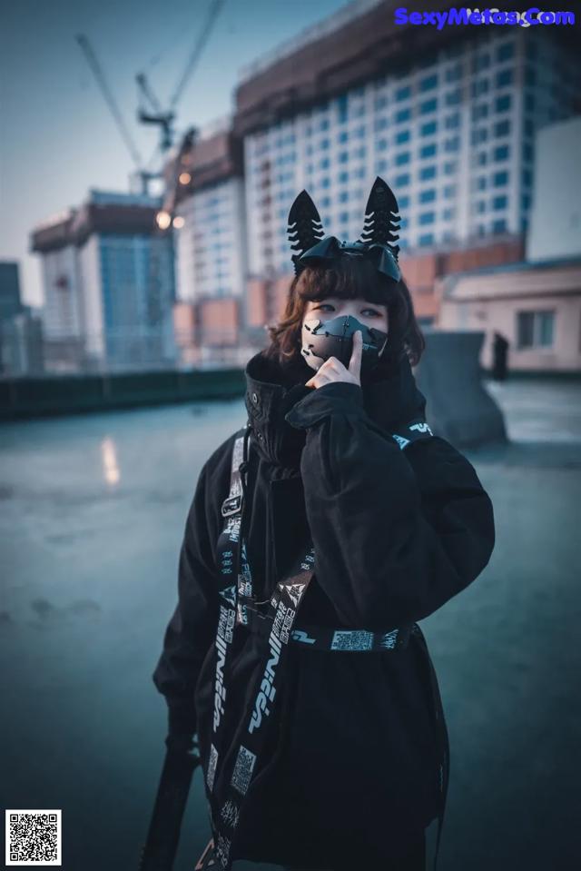A woman wearing a mask with horns on her head.