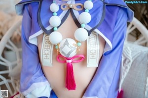 A woman in a blue and purple outfit sitting on a swing.