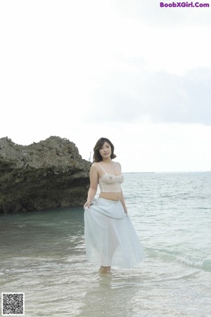A woman in a white lingerie posing for the camera.