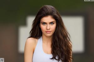 A woman in a white tank top posing for a picture.