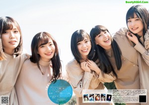 A group of young women posing for a photo in a field.