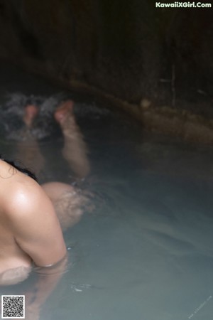 A woman in a white bikini sitting in a bathtub.