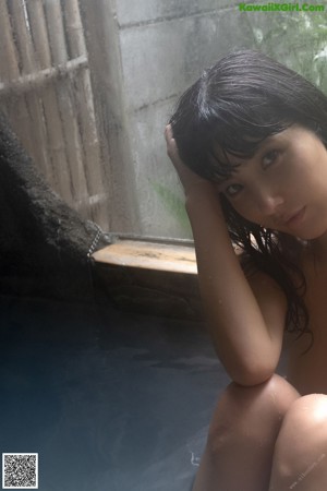 A woman with wet hair laying in a pool of water.