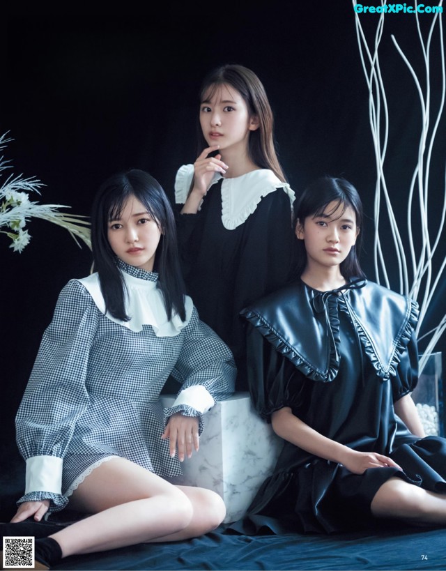 A group of three young women sitting next to each other.