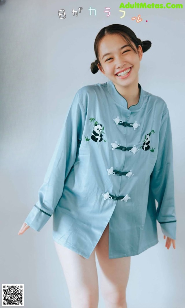 A woman wearing a blue shirt with panda embroidery on it.