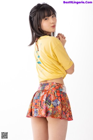 a woman in a yellow shirt and a colorful skirt