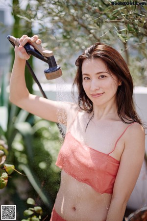A woman in a pink skirt is posing for the camera.