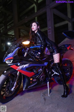 A woman sitting on a motorcycle in the dark.