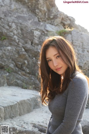 A woman sitting on the ground with her legs crossed.