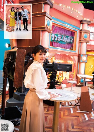 A woman in a white blouse posing for a picture.