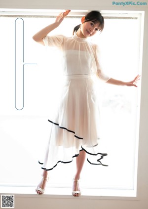 A woman standing in front of a table in a room.