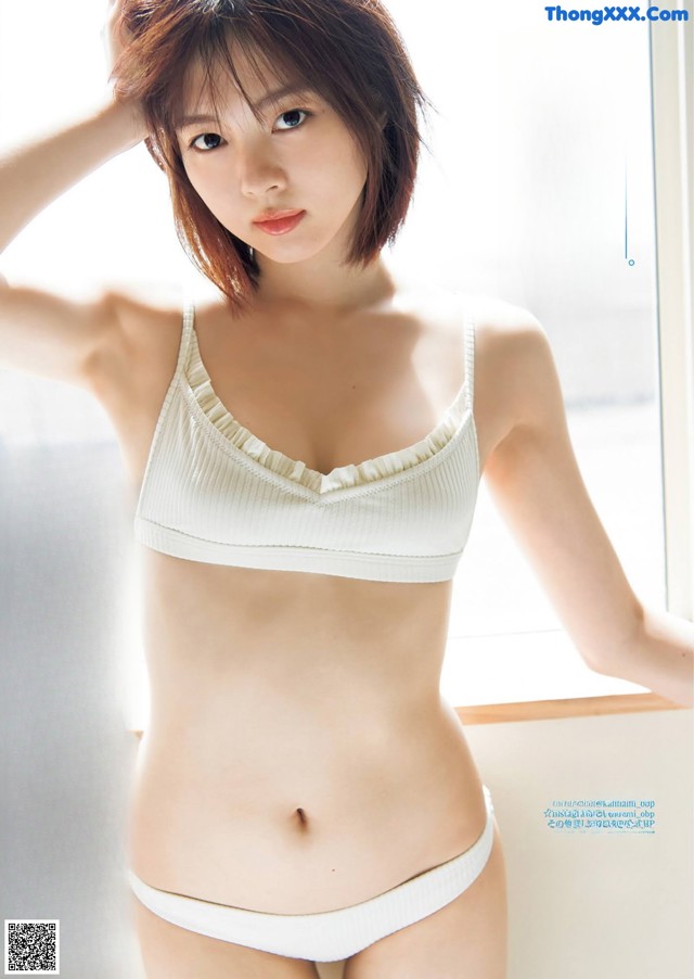 A woman in a white bra and panties posing for a magazine.