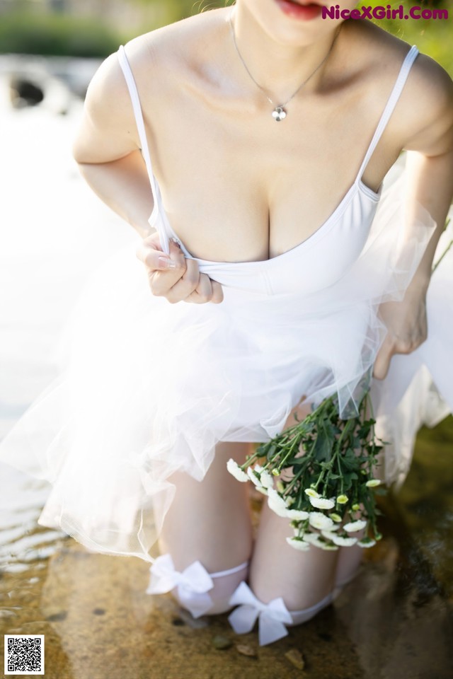 A woman in a white dress holding a bouquet of flowers.