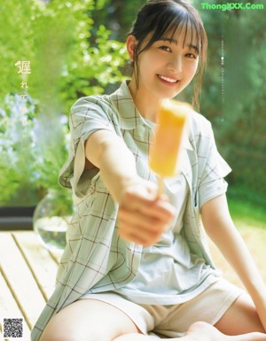 A woman in a straw hat holding an ice cream.