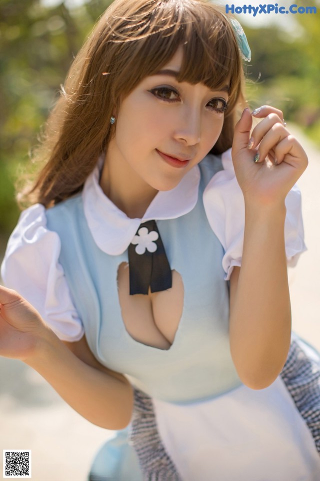 A woman in a blue and white dress posing for a picture.