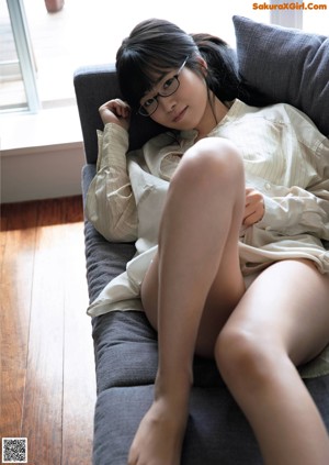 A woman sitting on a couch with her legs crossed.