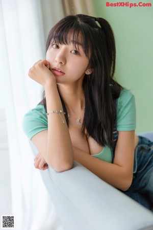 A woman sitting on a couch wrapped in a blanket.