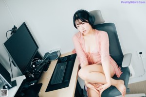 A woman sitting on a chair in front of a computer.