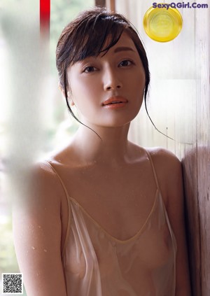 A woman in a bathtub with water splashing on her body.