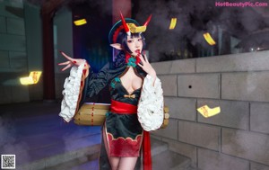 A woman dressed as a demon sitting on the ground.
