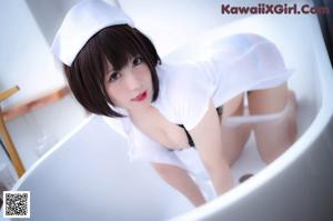 A woman in a white shirt and black panties in a bathtub.