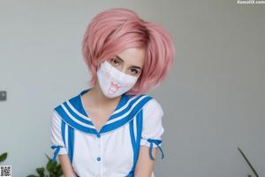 A woman standing on a beach next to the ocean.