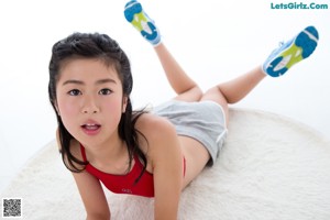 A young woman holding a hula hoop in her hands.