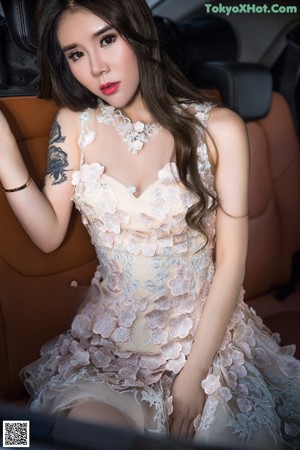 A woman in a dress sitting in a car.