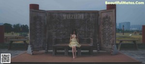 A woman standing on a balcony looking out over a city.