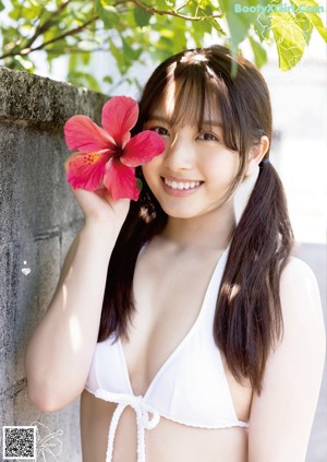 A woman in a white bikini laying on the ground.