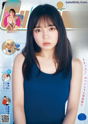 A woman in a blue tank top leaning against a wall.